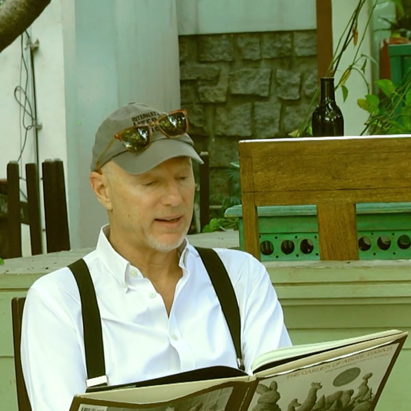 Man in ballcap reading out of a story book