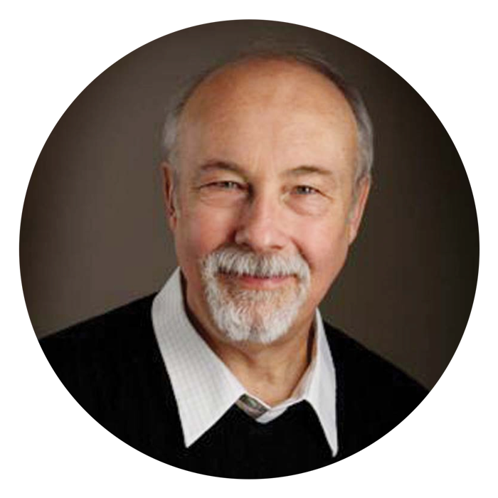 Man with with gray goatee in black sweater smiling